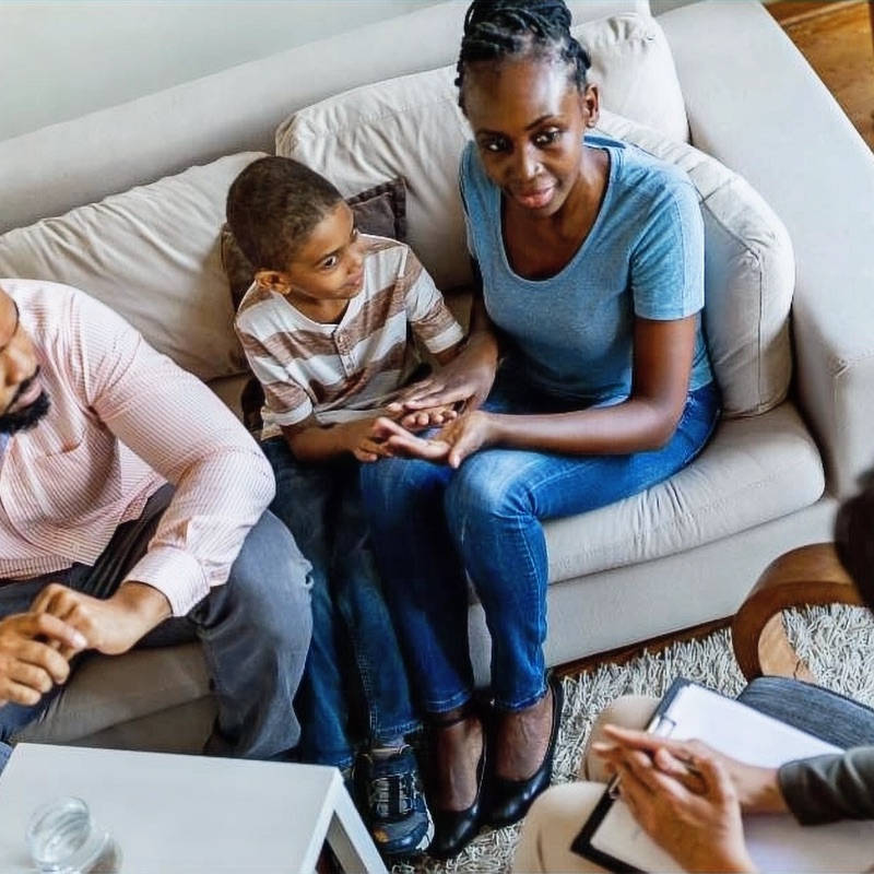 A family meeting with a Cove ABA professional in their living room